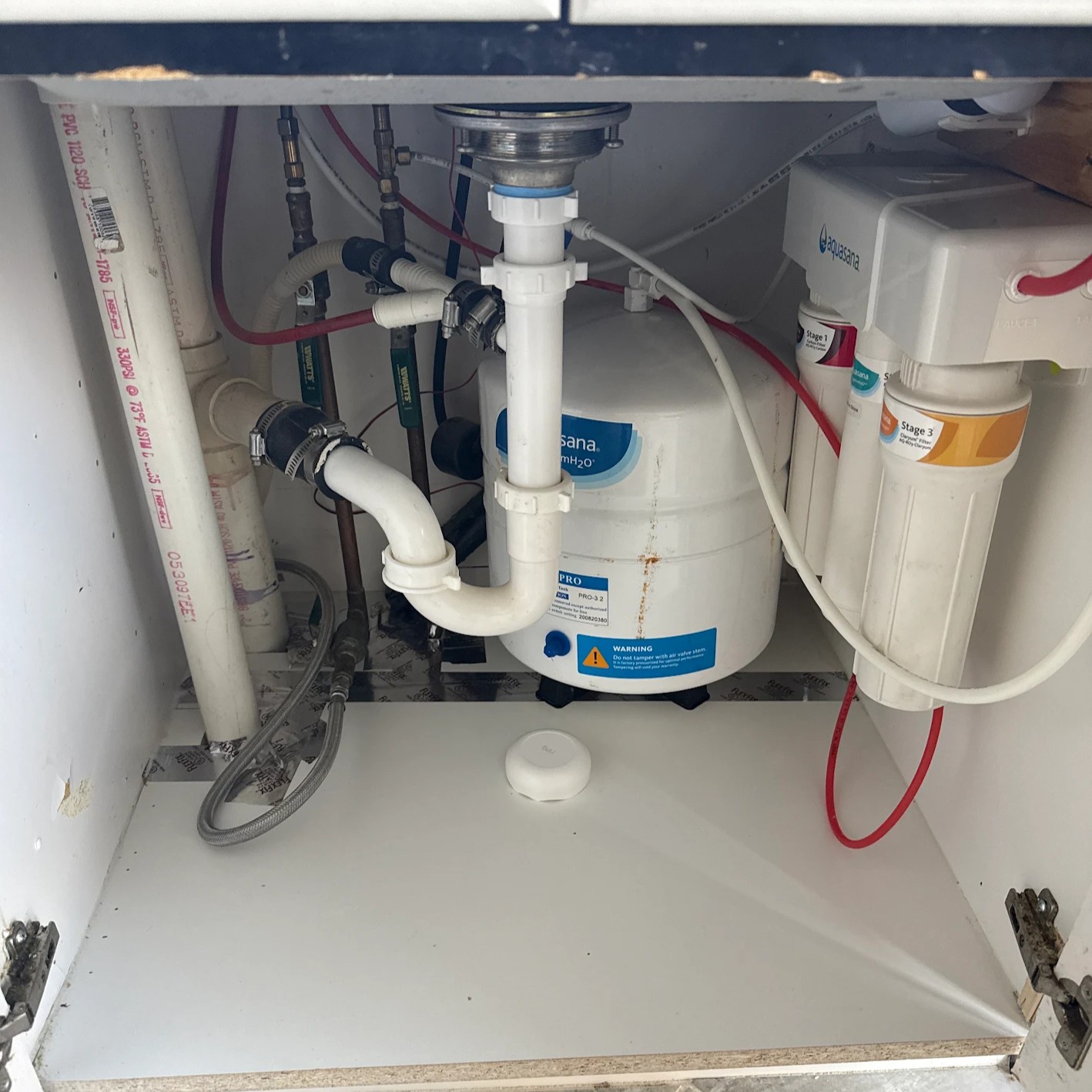 Leaking pipes and water filtration system Leaking pipes and water filtration system under kitchen sink before repair